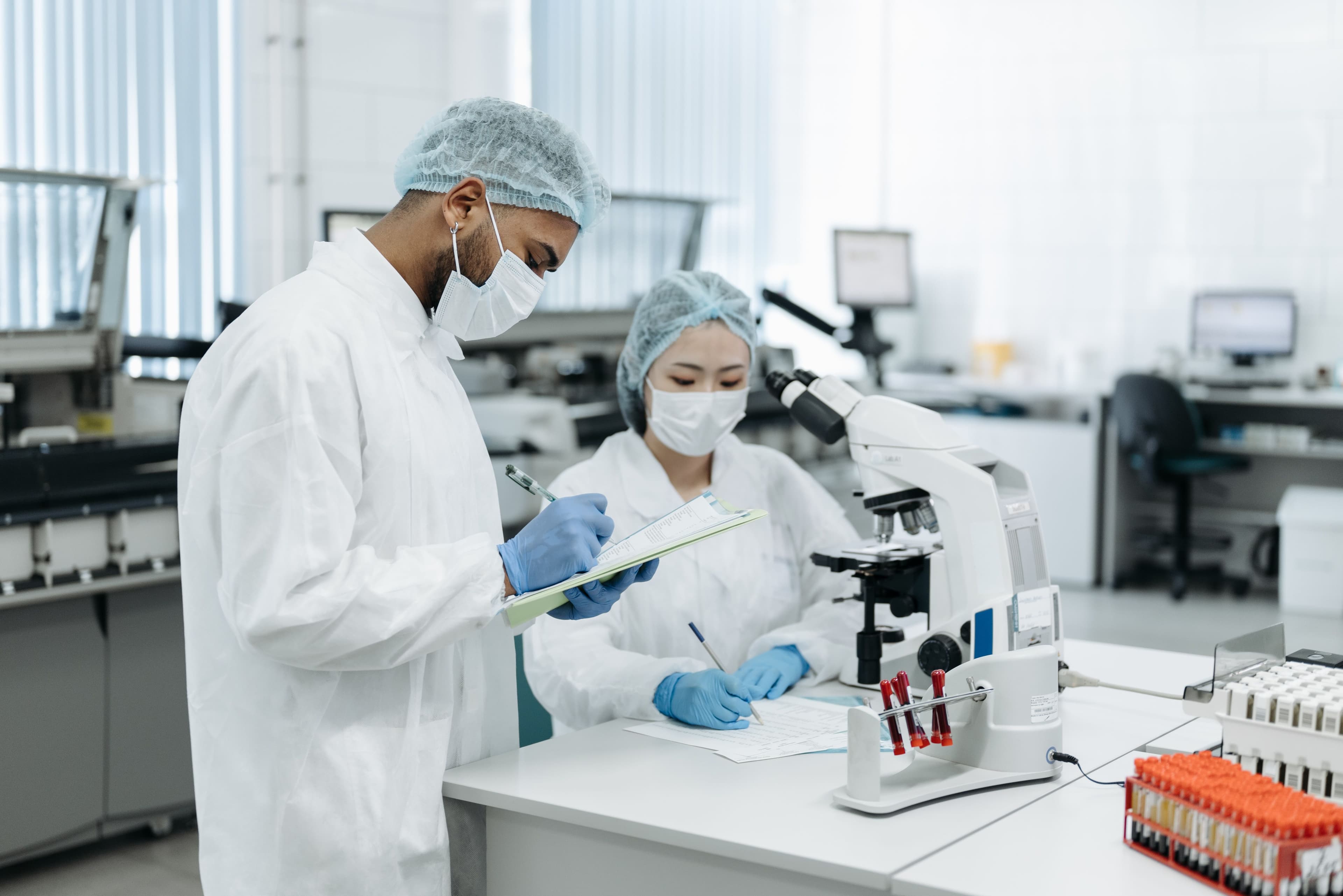 Lab professionals working with microscope and samples